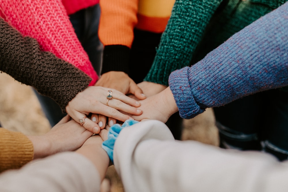 Diverse group stacking hands in solidarity